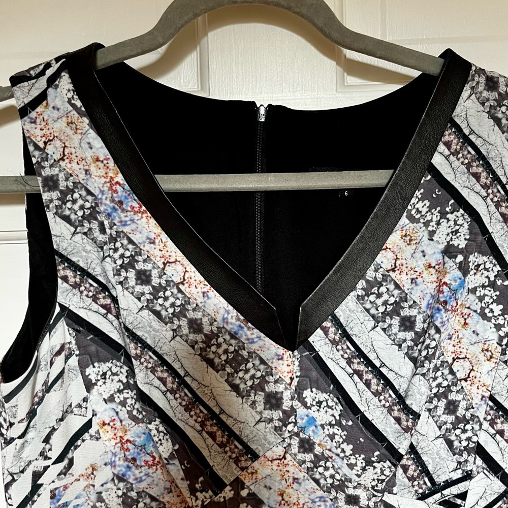 Sleeveless dress with leather trimmed vneck and light pleats on bottom